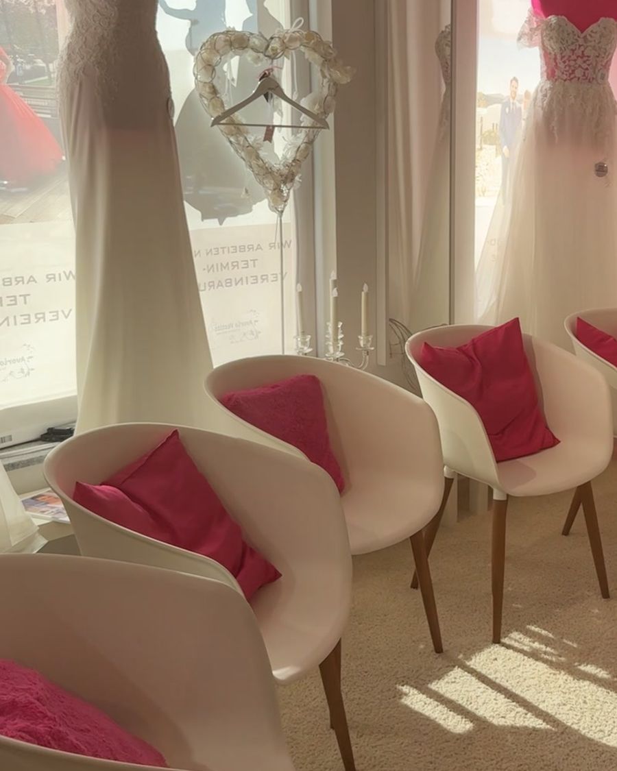 Weiße Sessel mit pinken Kissen vor dem Spiegel